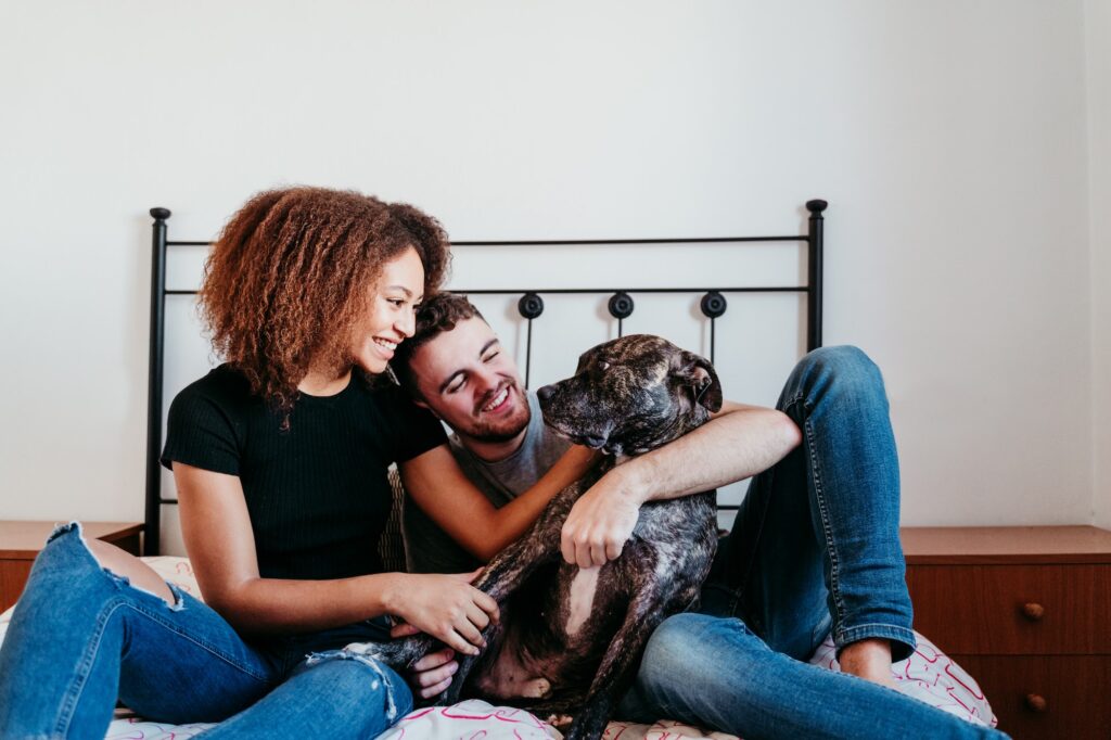 happy inter racial couple with dog at home. Afro american woman and caucasian man.ethnic love